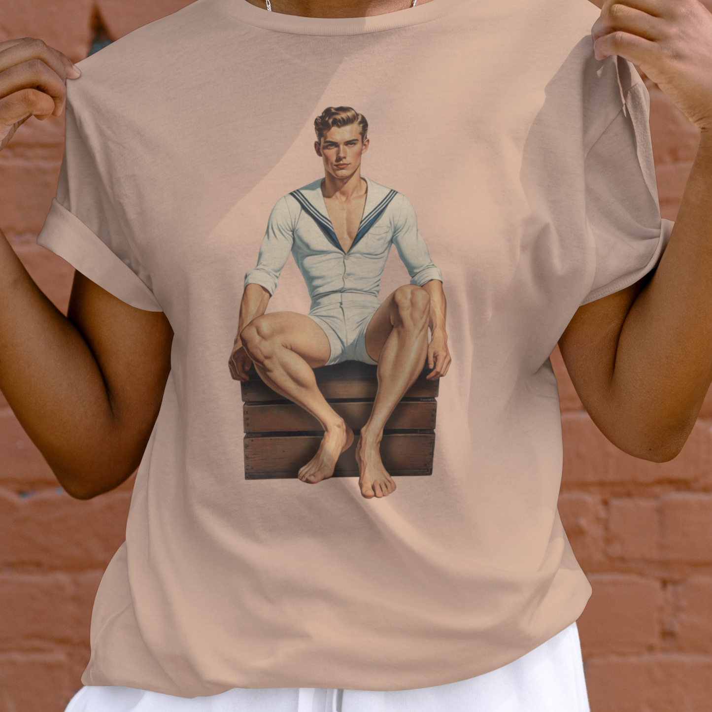 Person wearing a beige t-shirt with a graphic of a man in a sailor outfit.