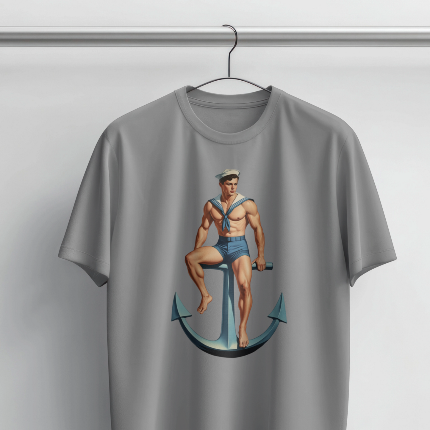 Gray t-shirt with a graphic of a sailor sitting on an anchor on a hanger against a light gray background