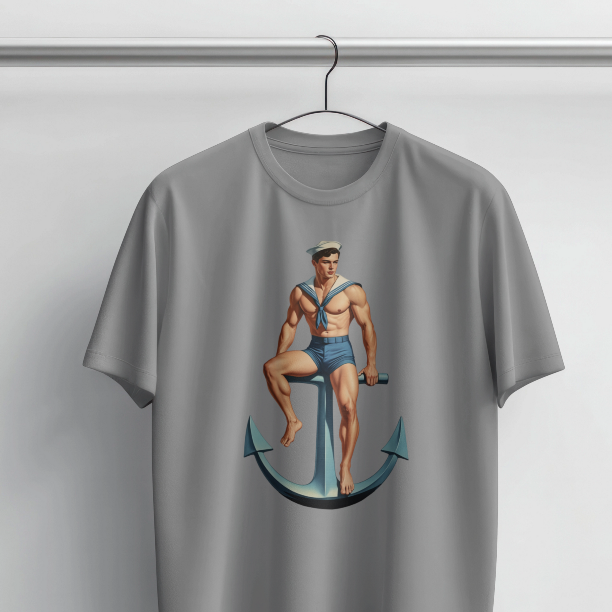 Gray t-shirt with a graphic of a sailor sitting on an anchor on a hanger against a light gray background