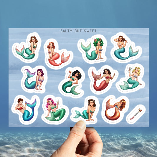 Sheet of mermaid stickers held over a blue water background