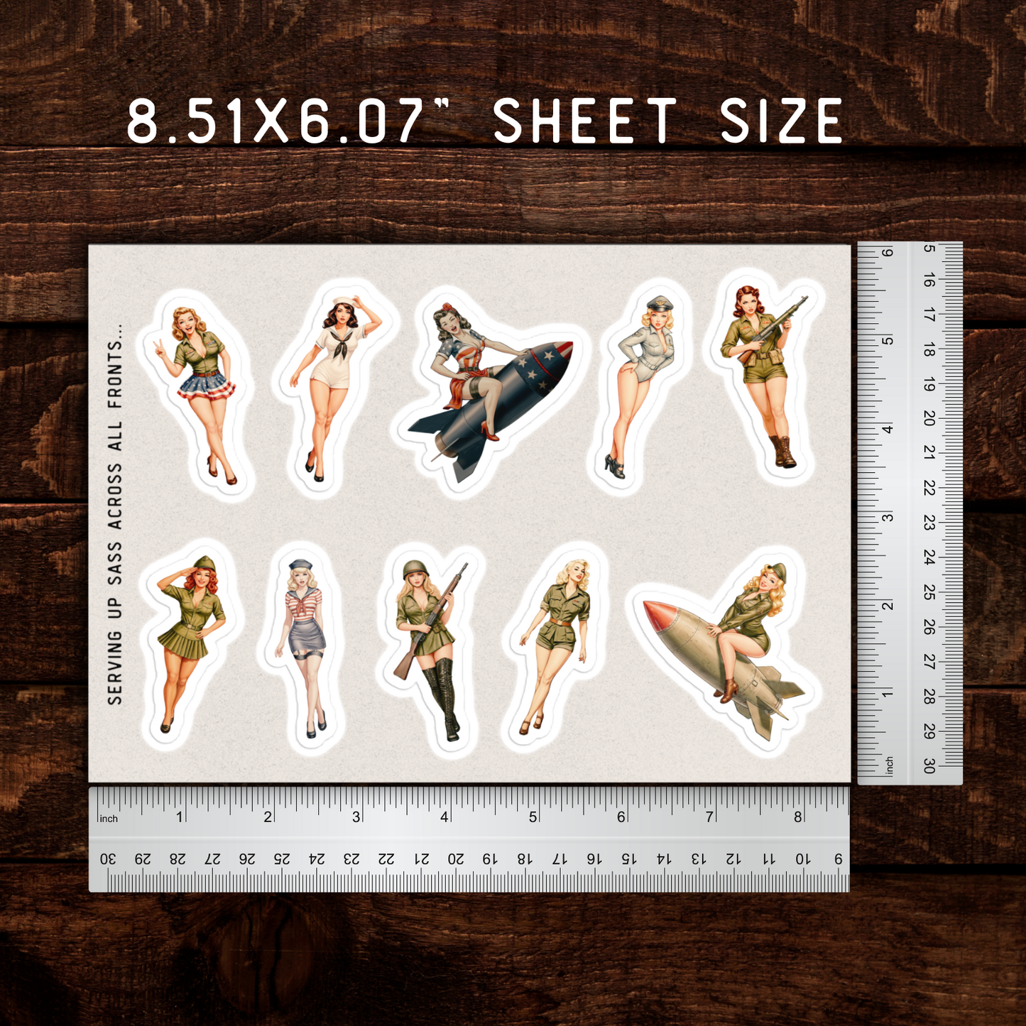 Sheet of stickers with military-themed designs on a wooden surface with rulers for scale.