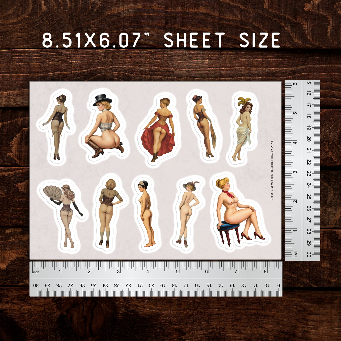 Sheet of stickers with illustrated women on a wooden surface with a ruler for scale.